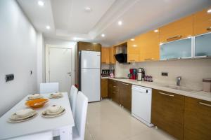 安塔利亚River Park Residence Lara的厨房配有白色桌子和白色冰箱。