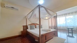 蒙巴萨Ary Beachfront Homestay Nyali- On Mombasa Beach的一间卧室配有一张四柱床和天蓬