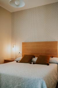 托雷德尔马尔Apartamentos Poniente - Mares的一间卧室配有一张大床和木制床头板