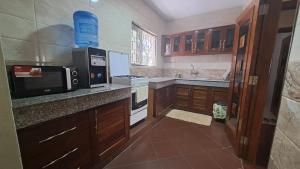 蒙巴萨Ary Beachfront Homestay Nyali- On Mombasa Beach的厨房配有微波炉和炉灶。