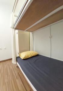 外南梦ROOM Ijen Dormitory & Tours的一张位于小房间的床,配有黄色枕头