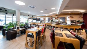 米特尔巴赫R&R Residenzen Ferienwohnungen的一间带木桌椅的餐厅和一间酒吧