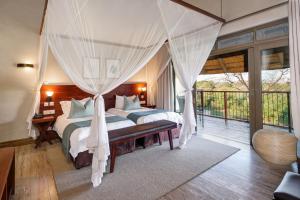 维多利亚瀑布伊拉拉山林小屋酒店的一间带两张床的卧室和一个阳台