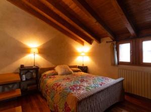 埃尔塔特Bombonera romántica con vistas a Grandvalira的一间卧室配有一张带两盏灯的床和两扇窗户。