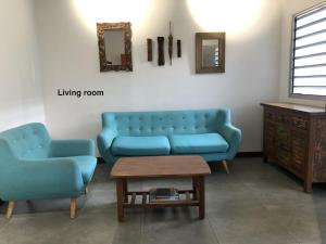 努美阿The Hideway的客厅配有2张蓝色的沙发和1张桌子