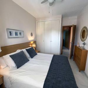 圣玛丽亚港Apartamento en la playa de Valdelagrana的卧室配有带蓝色枕头的大型白色床