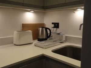 特威克纳姆Stylish Studio Apartment, ensuite, kitchenette的厨房柜台配有咖啡机和烤面包机