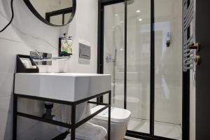 里斯本Duplo Charme Boutique Hotel的浴室配有白色水槽和淋浴。