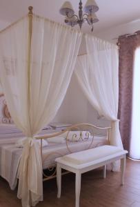内比达Guest House Bellavista Nebida的卧室配有白色的天蓬床和长凳