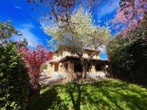 拉斯卡弗里亚曼扎诺斯乡村酒店的草坪上的房子,上面有树木和椅子