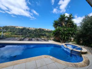 Għajn il-KbiraExclusive Pool with your own views with 3 bedrooms and 4 bathrooms in Gozo的棕榈树庭院中的游泳池