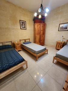 Għajn il-KbiraExclusive Pool with your own views with 3 bedrooms and 4 bathrooms in Gozo的一间卧室设有两张床和两个床头柜