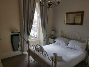 卡迪根Llety Teifi Guest House的卧室配有白色的床和窗户。