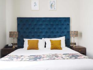 伯恩茅斯Hotel Collingwood BW Signature Collection的一张带蓝色床头板和2个床头柜的床
