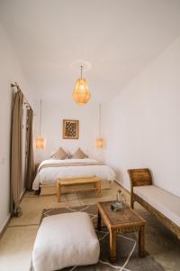 马拉喀什Riad Rahal的一间卧室配有一张床、一张沙发和一张桌子