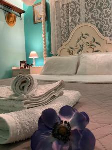 萨拉米斯Saronic Seafront的卧室配有带毛巾和花卉的床铺,位于地板上