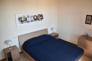 佩斯基耶拉德加达Esclusivo trilocale con piscina al Garda Resort Village的一间卧室配有蓝色的床和2个床头柜