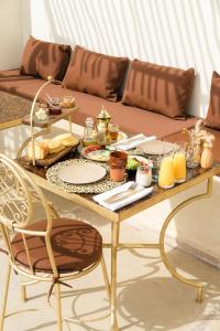 马拉喀什Riad Rahal的客厅里一张带食物的桌子和一张沙发