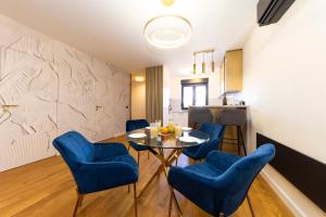 扎达尔Luxury House near the Uskok Beach的一间配备有蓝色椅子和桌子的用餐室