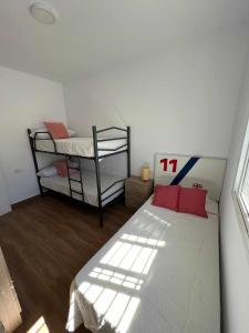 加的斯Villa Zen, La Barrosa的一间卧室配有一张床和两张双层床。