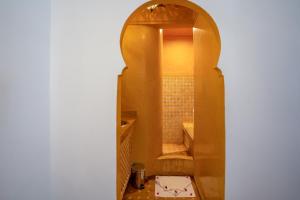 马拉喀什riad dar nejma & Spa的拱门通往带淋浴的浴室