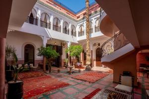 马拉喀什riad dar nejma & Spa的一座有树木和地毯的建筑中的庭院