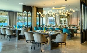 玛里纳Marinus Beach Hotel的一间带桌椅和吊灯的餐厅