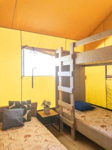 维亚雷焦Glamping tent with bathroom - Tuscany next to sea!的一间卧室设有双层床和黄色的墙壁