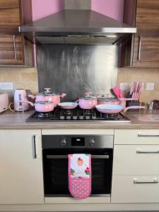 利物浦The Pink Jungle, Yes It Exists!的厨房配有粉色锅和炉灶