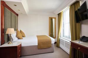 伦敦The Prime London Hotel的酒店客房设有床和窗户。