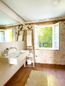 SospiroloCasa delle Arti Fattoria dei fiori的一间带水槽的浴室和两个窗户