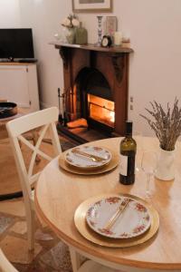 谭伯连山Enchanting Retreat - The English Cottage at Tamborine Mountain的一张桌子,上面放两个盘子和一瓶葡萄酒