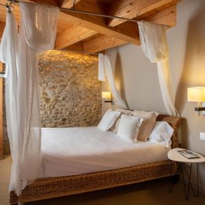 帕劳·萨巴尔德拉Hotel Boutique Niu de Sol - Designed for Adults的卧室配有带白色枕头的天蓬床