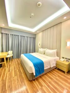 TanauanBravo Tanauan Hotel的一间卧室配有一张大床和一张书桌