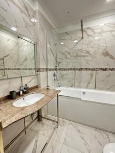 基希讷乌Villa ACAEM的浴室配有水槽、淋浴和浴缸。