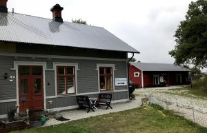 BurgsvikTågmagasinet Fidenäs的灰色的房子,后面有一座红色的建筑