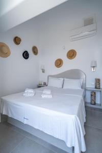 卡特瑞杜斯Acrus Villa Santorini with Heated pool的白色卧室配有一张大白色床和2条毛巾