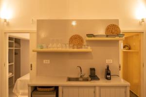 卡特瑞杜斯Acrus Villa Santorini with Heated pool的厨房配有水槽和餐具架