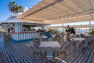 多列毛利诺斯MS特罗皮卡纳酒店的一间餐厅,配有桌椅,位于伞下
