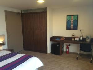 阿尔哈姆拉美景酒店的一间酒店客房,配有一张床、一张书桌和一扇门