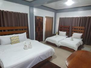 科隆科隆卡里斯景点旅馆的一间卧室配有两张带白色床单的床