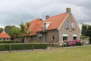 巴勒姆Ballumerhoeve Petit lodge的一座带橙色屋顶和庭院的房子