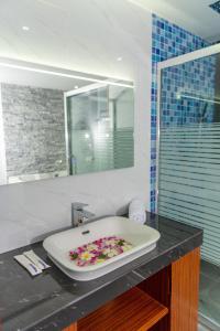丹格迪Ari Grand Hotel & Spa的浴室设有浴缸,在柜台上摆放着鲜花