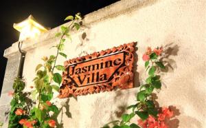 圣吉吉Jasmine Villa Senggigi的花墙边的标志