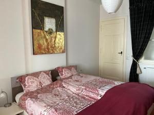 芬洛inn Venlo Apartment的卧室配有一张床,墙上挂有绘画作品