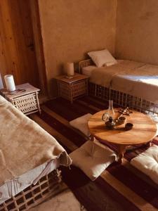 锡瓦Tanirt ecolodge的客房设有两张床和一张木桌。
