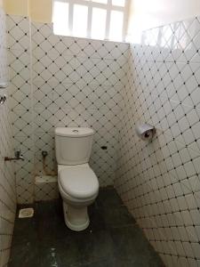 埃尔多雷特Denverwing Homes的白色瓷砖墙内带卫生间的浴室
