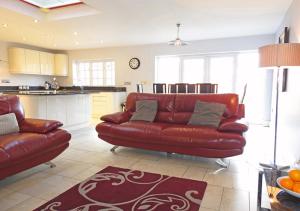 戈斯波特Coach House的一间带红色沙发的客厅和一间厨房