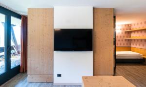 摩德纳迪-坎皮格里奥安比耶兹公寓酒店的墙上配有平面电视的房间
