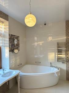 敖德萨Villa-Sofia Mini-hotel的白色的浴室设有浴缸和水槽。